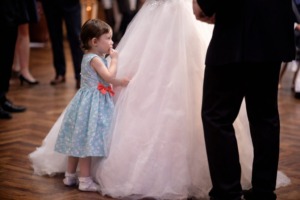 Children on the dacne floor during the wedding dance Unsupervised child behind the bride’s gown during a wedding first dance, illustrating the risk of children getting hurt if unnoticed on the dance floor.