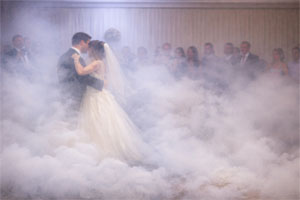 no fog during your wedding dance Bride and groom sharing their first wedding dance surrounded by artificial fog on the dance floor, showing how heavy fog can obscure the couple and reduce visibility during a wedding dance.